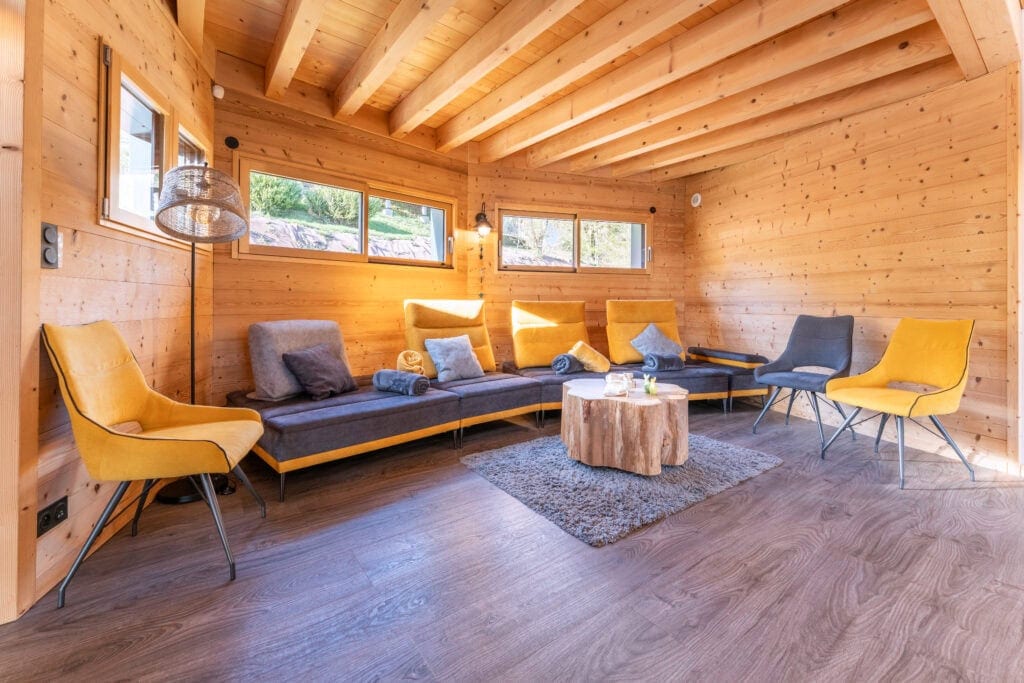 Luxueuse salle de séjour en bois avec canapé moderne, fauteuils colorés et décoration chaleureuse.