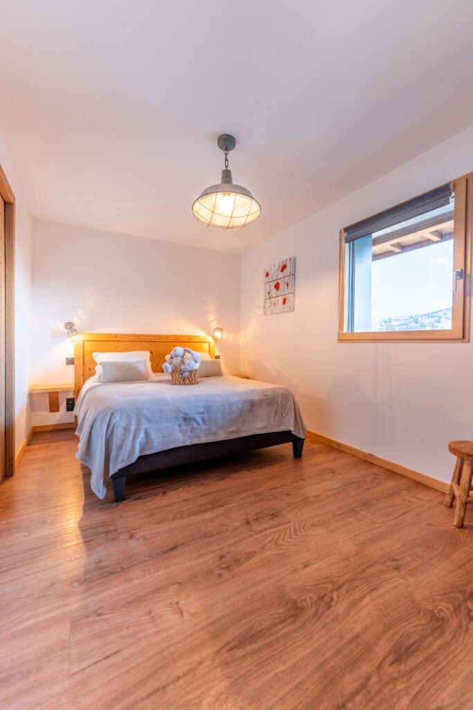 Chambre lumineuse avec lit double et vue sur la nature à La Bresse.