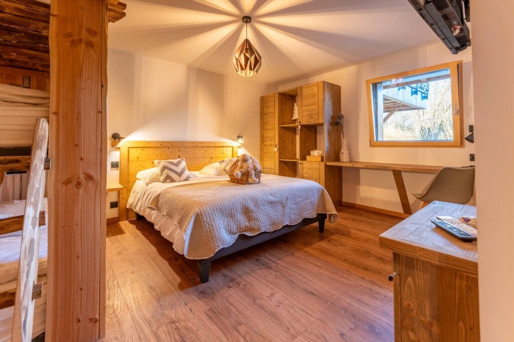 Lits en bois dans une chambre chaleureuse en chalet, vue chaleureuse et ambiance cosy à La Bresse.